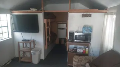 a room with a tv and a living room with a couch at Two Creeks Camp in Athens