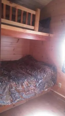 a bunk bed in a wooden cabin with a mattress at Two Creeks Camp in Athens