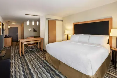 a hotel room with a large bed and a desk at Wyndham Avon in Avon Center