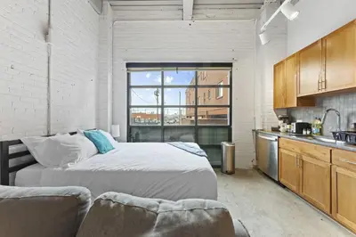 a bedroom with a large bed and a kitchen at 2125 Superior Living in Cleveland