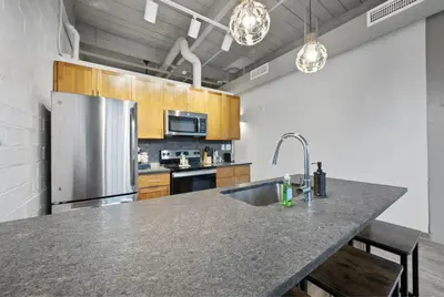 a kitchen with a stainless steel refrigerator and a sink at 2125 Superior Living in Cleveland