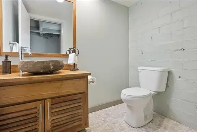 a bathroom with a toilet and a sink with a mirror at 2125 Superior Living in Cleveland