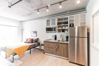 a kitchen and living room with a stainless steel refrigerator at Urban Elegance Studio Oasis Prime Location in Cleveland