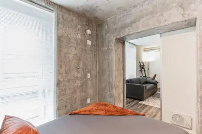 a bedroom with a large mirror and a couch at Sleek downtown Cleveland apartment in Cleveland