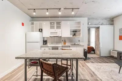 a kitchen with white cabinets and a table and chairs at Sleek downtown Cleveland apartment in Cleveland