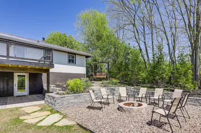 a patio with chairs and a fire pit in front of a house at Dry Ridge Farmhouse with Hot Tub and Game Room! in Dry Ridge