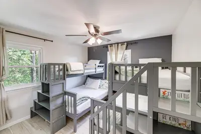 a room with bunk beds and a ceiling fan at Dry Ridge Farmhouse with Hot Tub and Game Room! in Dry Ridge