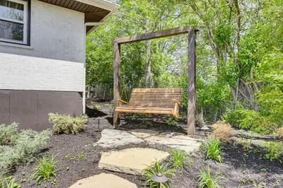 a wooden bench sitting next to a building at Dry Ridge Farmhouse with Hot Tub and Game Room! in Dry Ridge