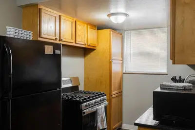 a kitchen with a black refrigerator and wooden cabinets at Maple Heights Serenity Libby Unit 2 in Maple Heights