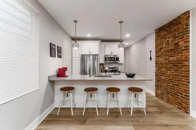a kitchen with a counter and three stools in it at Entire Home Private Parking Fenced Yard in Columbus