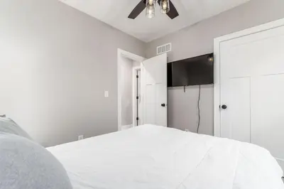 a white bedroom with a bed and a ceiling fan at Entire Home Private Parking Fenced Yard in Columbus