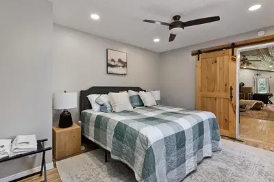 a bedroom with a bed and a ceiling fan at Spacious Cabin Near Hocking Hills and Caves with Hot Tub and Firepit in Laurelville
