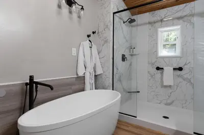 a bathroom with a white toilet and a shower at Spacious Cabin Near Hocking Hills and Caves with Hot Tub and Firepit in Laurelville