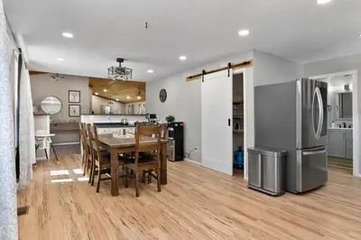 a kitchen and dining room with a table and a refrigerator at Spacious Cabin Near Hocking Hills and Caves with Hot Tub and Firepit in Laurelville