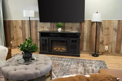 a living room with a fireplace and a tv at Spacious Cabin Near Hocking Hills and Caves with Hot Tub and Firepit in Laurelville
