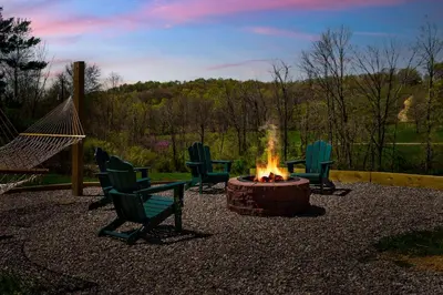 a group of chairs around a fire pit at Spacious Cabin Near Hocking Hills and Caves with Hot Tub and Firepit in Laurelville