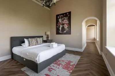 a bedroom with a large bed and an archway at Above Coffee Shop, Cincy Hilltop Apt, City Views! in Cincinnati
