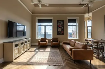 a living room with a couch and a flat screen tv at Above Coffee Shop, Cincy Hilltop Apt, City Views! in Cincinnati