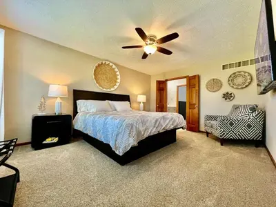 a bedroom with a bed and a ceiling fan at Suburban paradise in Liberty TWP in Hughes