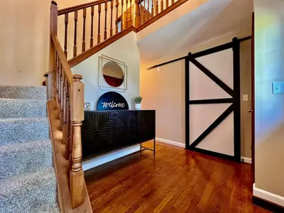 a sliding barn door in a home with a staircase at Suburban paradise in Liberty TWP in Hughes