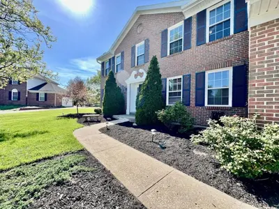 a brick house with a sidewalk in front of a yard at Suburban paradise in Liberty TWP in Hughes