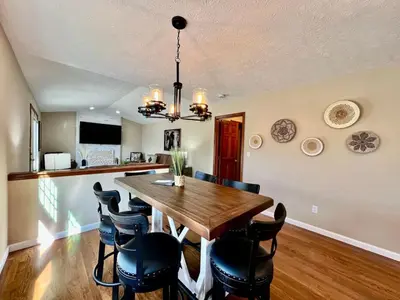 a dining room with a wooden table and chairs at Suburban paradise in Liberty TWP in Hughes