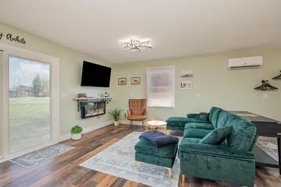 a living room with two green couches and a tv at The Carriage House in Warsaw