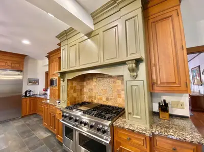 a kitchen with wooden cabinets and a stove top oven at Luxurious Mansion for Large Groups in Cleveland Heights