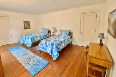 a bedroom with two beds and a wooden floor at Luxurious Mansion for Large Groups in Cleveland Heights