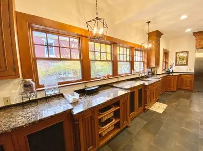 a large kitchen with wooden cabinets and windows at Luxurious Mansion for Large Groups in Cleveland Heights