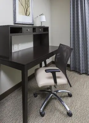 a black desk with a chair in a hotel room at Staybridge Suites Canton by IHG in North Canton