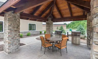 an outdoor patio with a table and chairs and a grill at Staybridge Suites Canton by IHG in North Canton