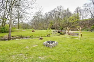 a park with a bench and a pond in the grass at Pet-Friendly Zanesville Haven with Game Room! in Zanesville