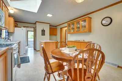 a kitchen with a wooden table and chairs at Serene Zanesville Getaway Hot Tub, 2 Decks! in Zanesville