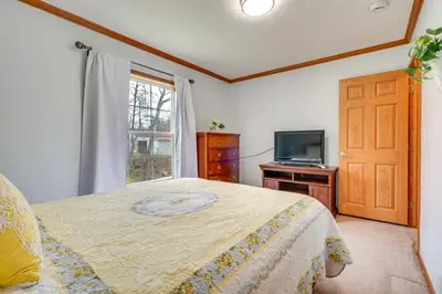 a bedroom with a bed and a tv and a window at Serene Zanesville Getaway Hot Tub, 2 Decks! in Zanesville