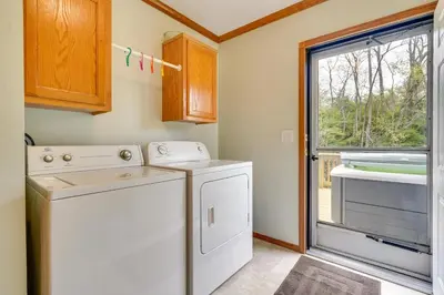 a laundry room with a washer and dryer and a window at Serene Zanesville Getaway Hot Tub, 2 Decks! in Zanesville