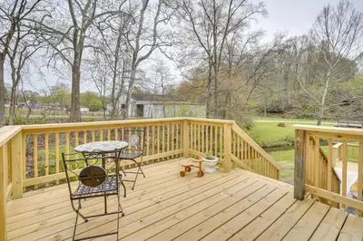 a wooden deck with a table and a chair on it at Serene Zanesville Getaway Hot Tub, 2 Decks! in Zanesville