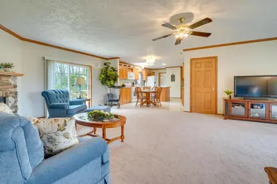 a living room with a blue couch and a tv at Serene Zanesville Getaway Hot Tub, 2 Decks! in Zanesville