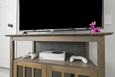 a television on a table with two video game controllers at Massive home downtown with Hot Tub in Columbus