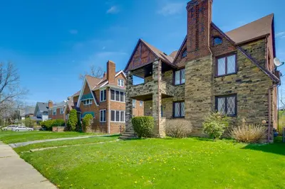 a large brick house on a green lawn at South Euclid Apt Less Than 10 Mi to Downtown Cleveland! in South Euclid