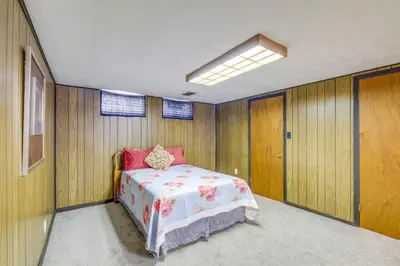 a bedroom with a bed in a room with wooden walls at Charming Home - 4 Mi to Euclid Creek Reservation in South Euclid