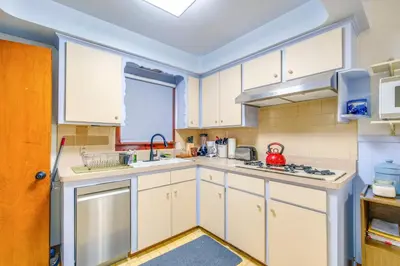 a kitchen with white cabinets and a sink at Charming Home - 4 Mi to Euclid Creek Reservation in South Euclid