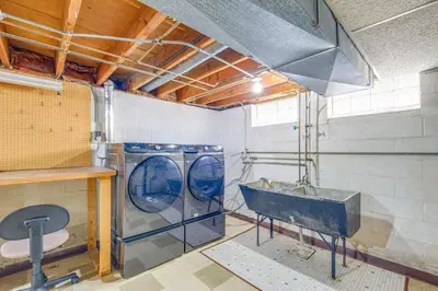 a laundry room with a washing machine and a sink at Charming Home - 4 Mi to Euclid Creek Reservation in South Euclid