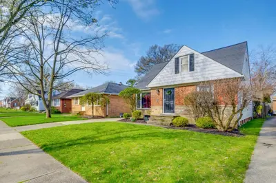 a house with a green lawn in front of it at Charming Home - 4 Mi to Euclid Creek Reservation in South Euclid