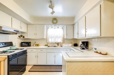 a kitchen with white cabinets and a stove top oven at Cleveland Heights Home with Sunroom Park Across St! in Cleveland Heights