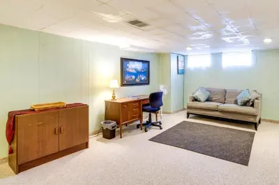 a living room with a couch and a desk at Cleveland Heights Home with Sunroom Park Across St! in Cleveland Heights