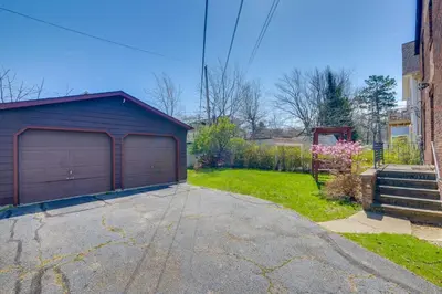 a garage in a driveway next to a house at Trendy South Euclid Apt - 5 Mi to Cleveland Clinic in South Euclid