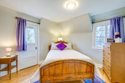 a bedroom with a wooden bed with purple curtains at Inviting Vacation Home 2 Mi to Mill Creek Falls! in Garfield Heights