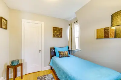 a bedroom with a blue bed and a window at Inviting Vacation Home 2 Mi to Mill Creek Falls! in Garfield Heights