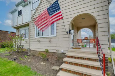 a house with an american flag on it at Inviting Vacation Home 2 Mi to Mill Creek Falls! in Garfield Heights